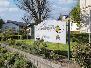 Schild für Hotel Restaurant Ammareier Gutshof mit den Logos von Graf Arco, Albin Bach und Weinstubn.