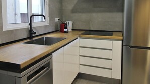 Eine Küche mit einem Edelstahl-Kühlschrank, einer doppelten Spüle und einer Kaffeemaschine auf der Arbeitsplatte.