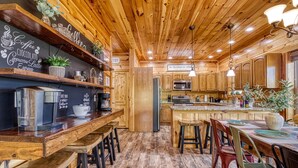 A wooden interior with a bar area, kitchen, and seating. - Royal Bliss - Mountain Views Theater Hot Tub (Sevierville)