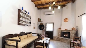 Un salón acogedor con un sofá de madera, una mesa de comedor y una chimenea.