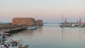 Una construcción fortificada con un foso y barcos amarrados cerca.