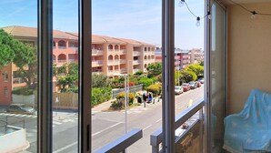 Une vue depuis une fenêtre, avec des ampoules, une rue et des immeubles à plusieurs étages.