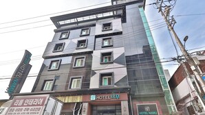 A multi-story hotel with a modern facade, featuring a prominent logo and signage indicating it is Hotel Namu. - Gyeongju hotel namu (Gyeongju)