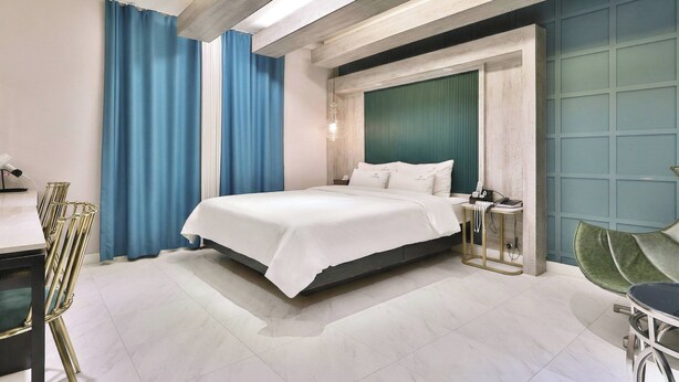 A modern hotel room with a large bed, a desk, and a chair. - Gyeongju hotel namu (Gyeongju)