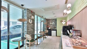 A modern cafe with a stone wall, large windows, and a buffet area. - Gyeongju hotel namu (Gyeongju)