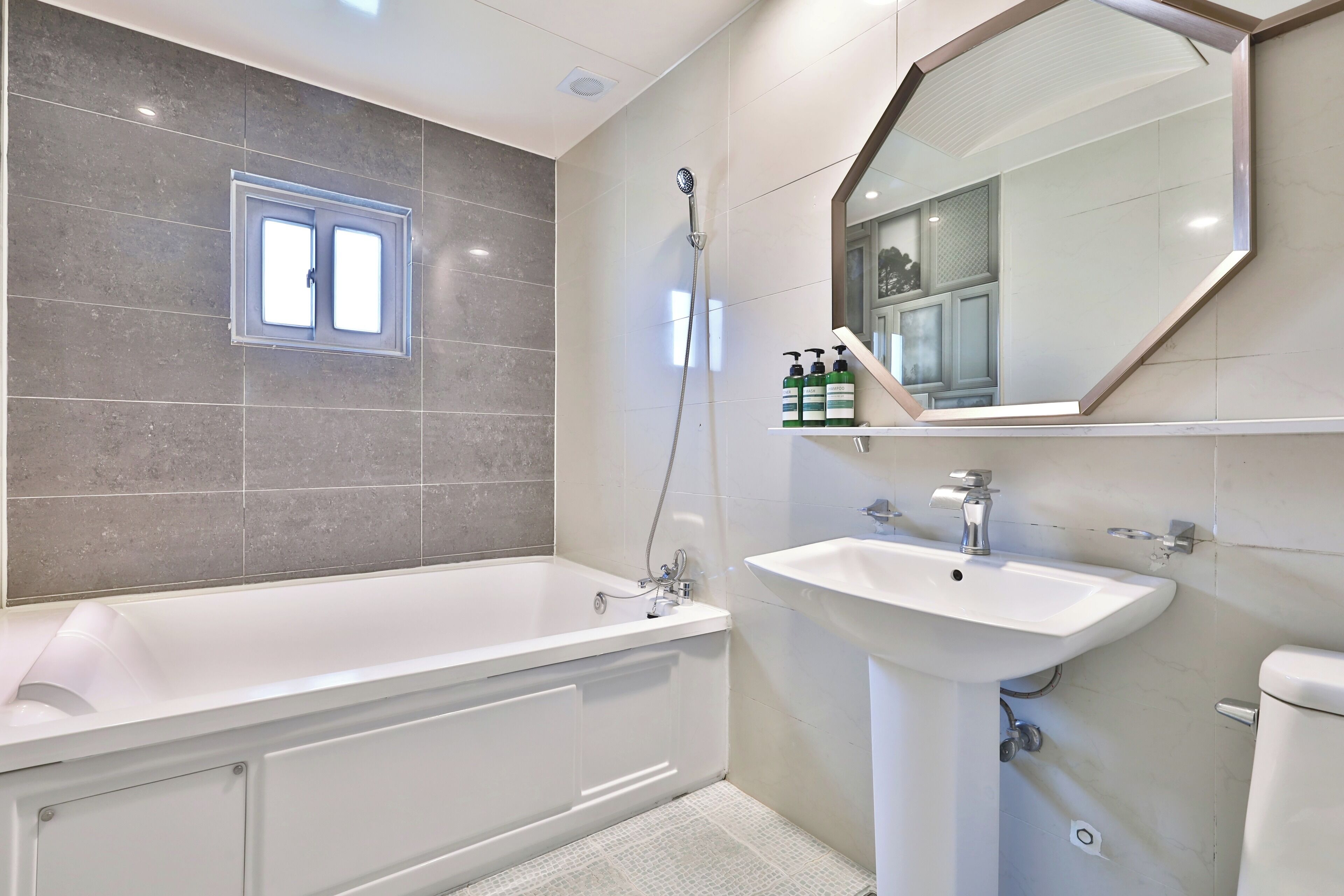 A modern bathroom with a bathtub, a sink, and a shower.