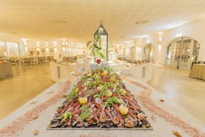 A spacious hotel dining area with a central seafood display, multiple tables, and a modern architectural design. - Futura Club Barone di Mare (Melendugno)