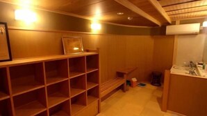 Een kamer met houten planken, een tafeltje en een wastafel met spiegel.
