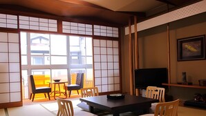 Een traditionele Japanse kamer met tatami vloerbedekking, een lage tafel en schuifdeuren.