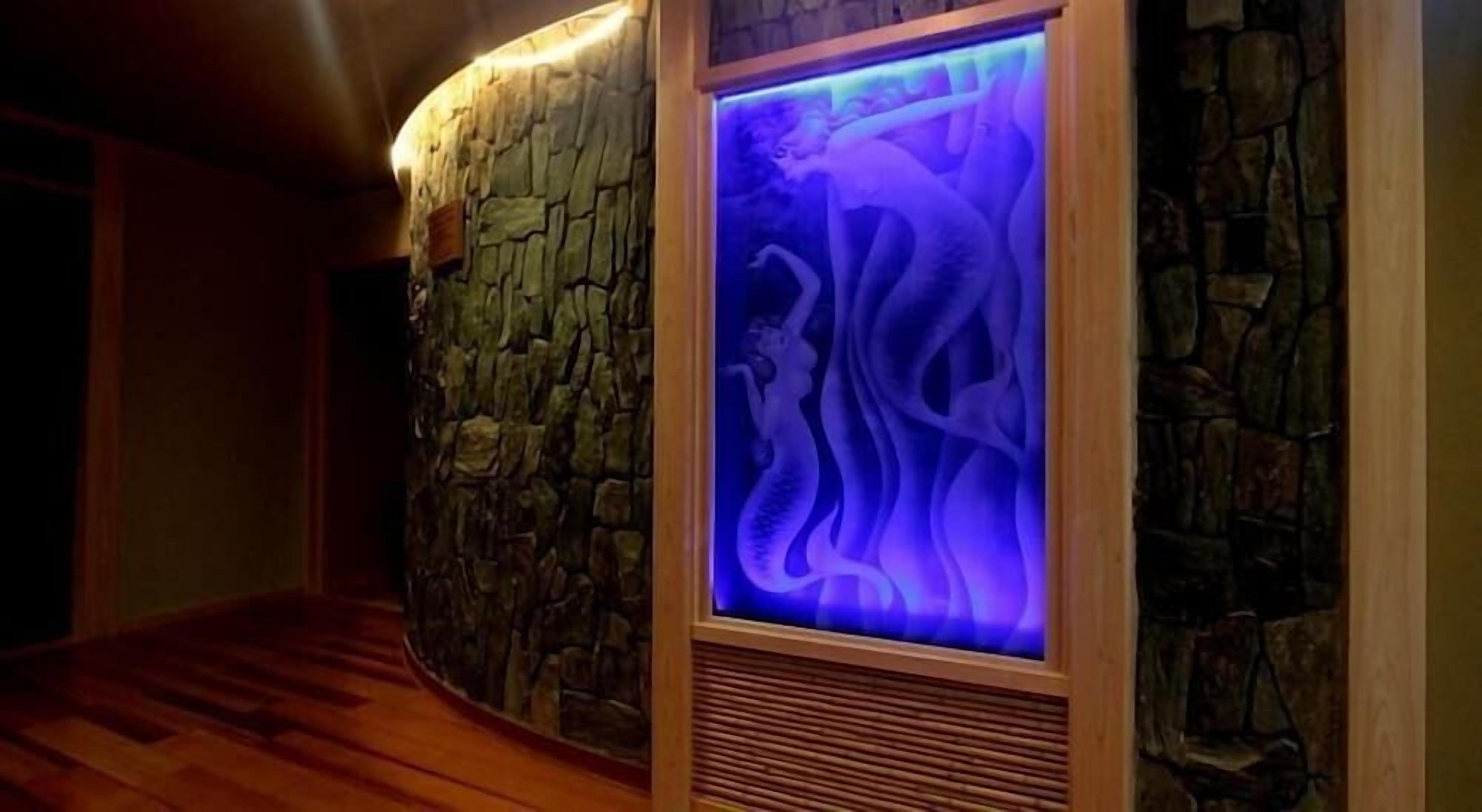 Un muro de piedra con un panel iluminado en azul.