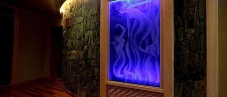 Un muro de piedra con un panel iluminado en azul.