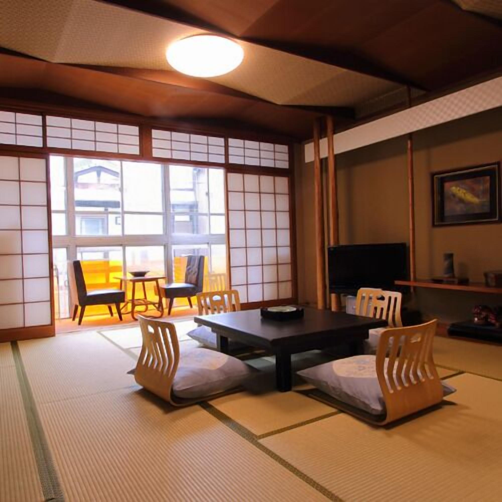 A traditional Japanese room with tatami flooring, a low table, and sliding doors.