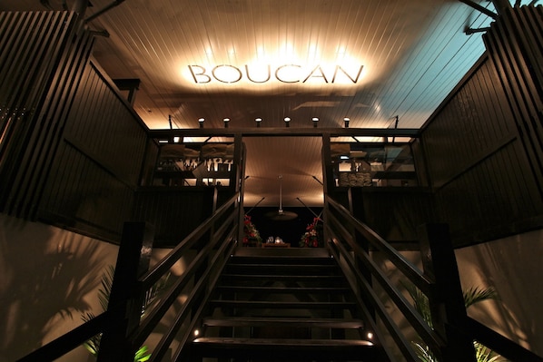 A staircase leading to a room with a sign reading "BOUCAN" on the ceiling. - Boucan BY Chocolat Hotel (Soufrière)