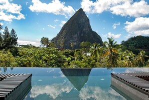 A clear view of a mountain, a pool with lounge chairs, and lush greenery. - Boucan By Chocolat Hotel (Soufrière)