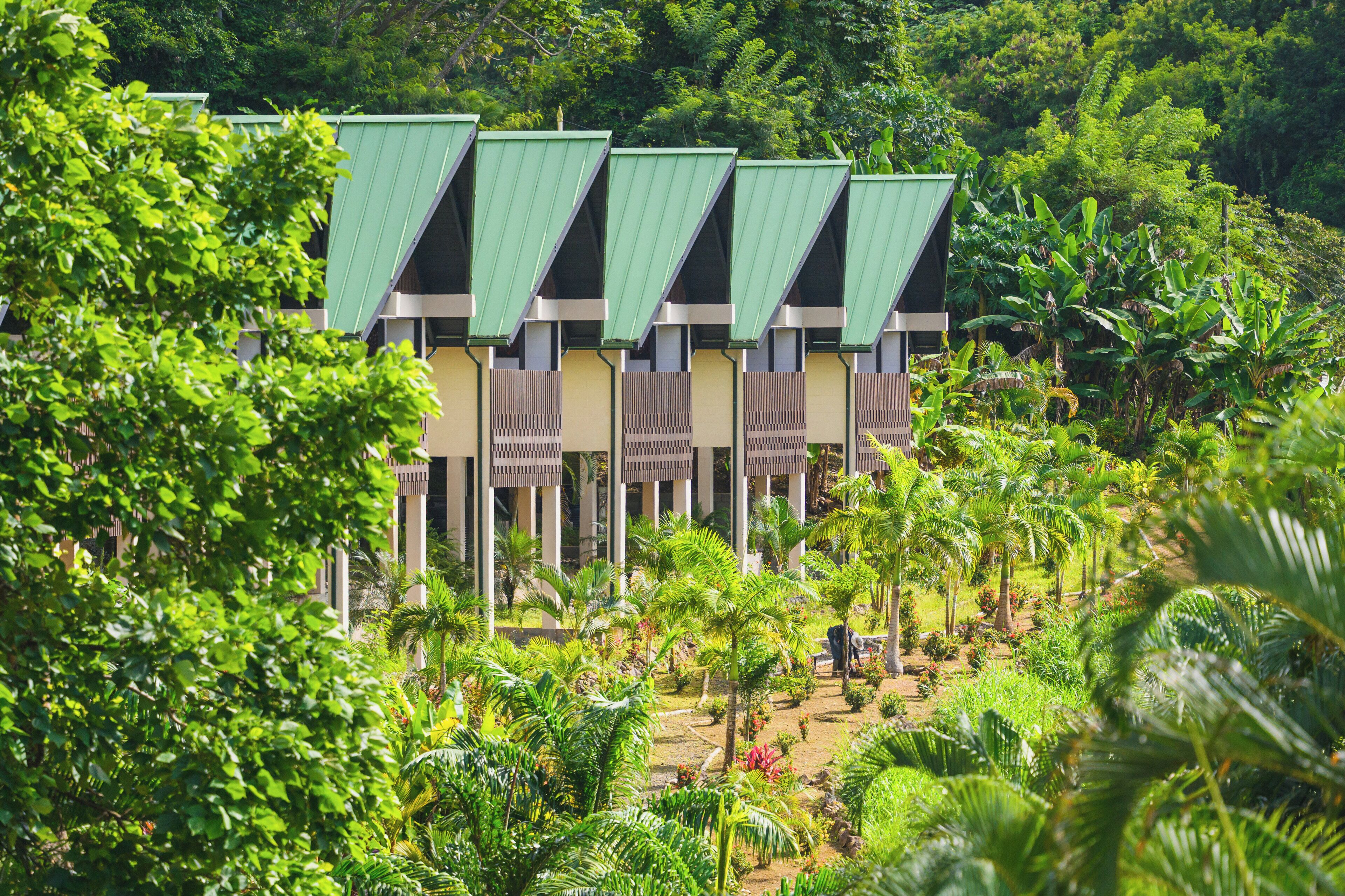 A hotel with multiple green-roofed buildings surrounded by lush greenery.