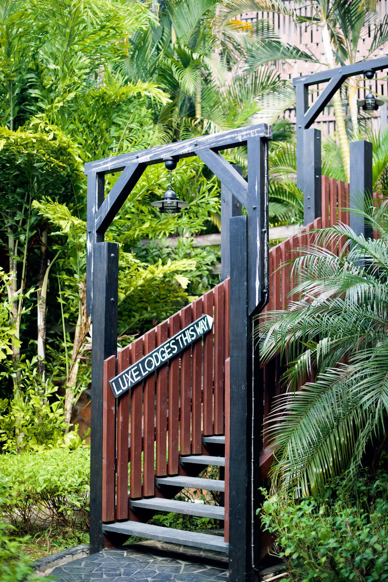 A wooden gate with a sign that reads "LIVE LODGES THIS WAY" leading to a staircase.