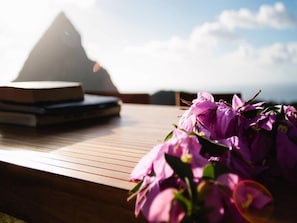 A wooden table with a laptop and books, and a bouquet of purple flowers. - Boucan BY Chocolat Hotel (Soufrière)