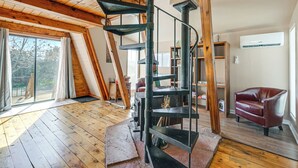A spacious loft with a spiral staircase, wooden beams, a fireplace, and a large window. - Hike, Bike & Atv! A-frame Rimrock Cabin w/ Views (Rimrock)