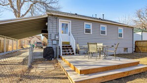 Ein Wohnhaus mit einer Garage, einer Terrasse mit Gartenmöbeln und einem Holzdeck.
