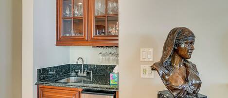 A kitchen with wooden cabinets, a stainless steel dishwasher, and a marble countertop.