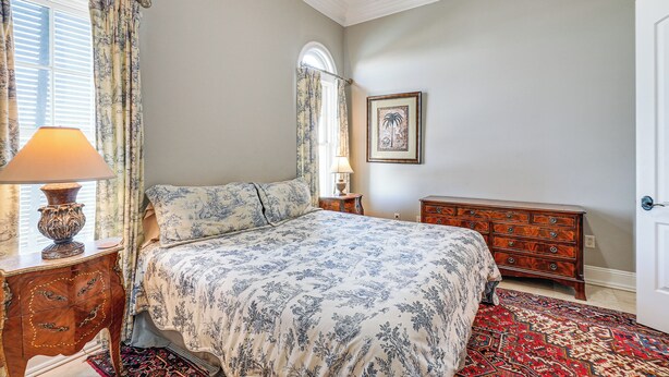 A bedroom with a bed, a dresser, a lamp, and a framed picture on the wall. - 'like No Other' in the Panhandle of Florida (Panama City Beach)