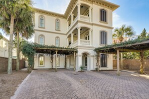 Un grand immeuble à étages, doté d’une façade symétrique, de nombreux balcons et d’une cour dallée.