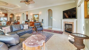 A spacious living room with a fireplace, leather sofas, a coffee table, and a large TV. - 'like No Other' in the Panhandle of Florida (Panama City Beach)