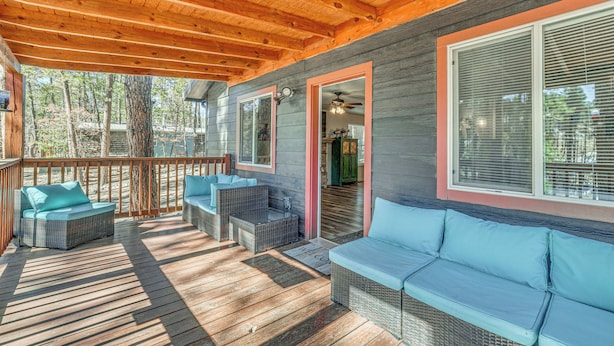 Eine überdachte Terrasse im Freien mit Korbmöbeln und Holzboden.