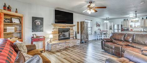 A spacious living room with a fireplace, leather sofas, and a flat-screen TV.