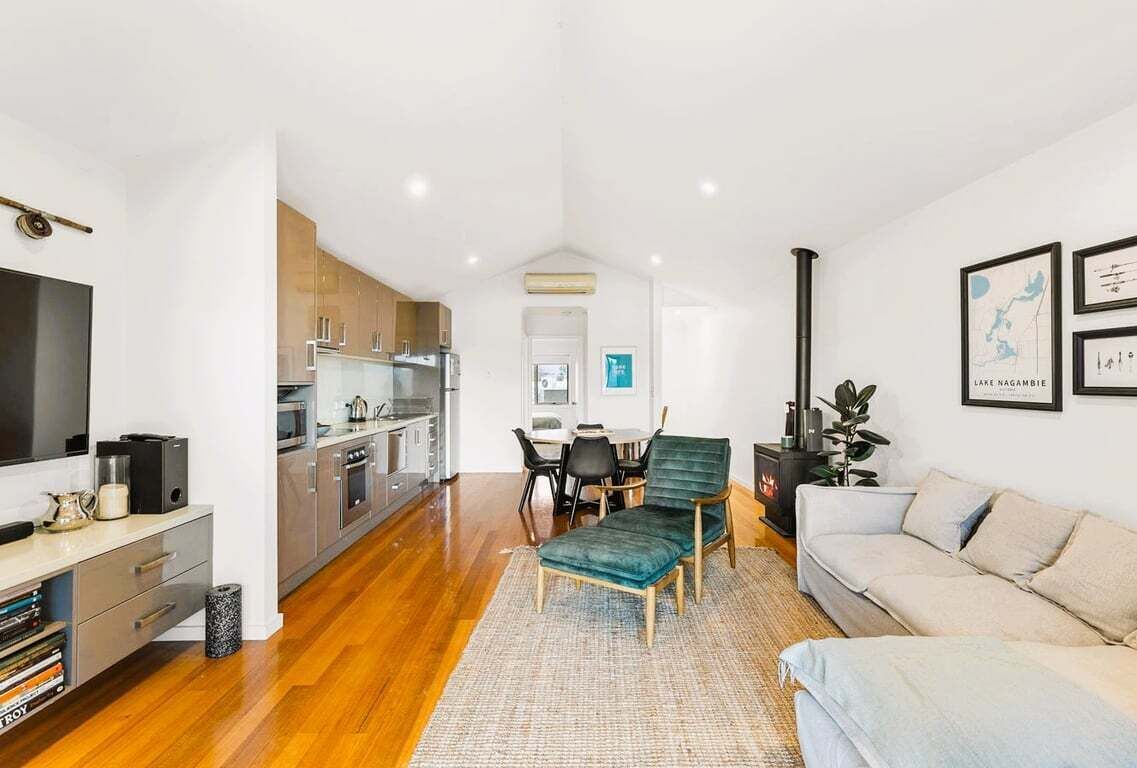 A modern living space with a kitchen, dining area, and a sofa.
