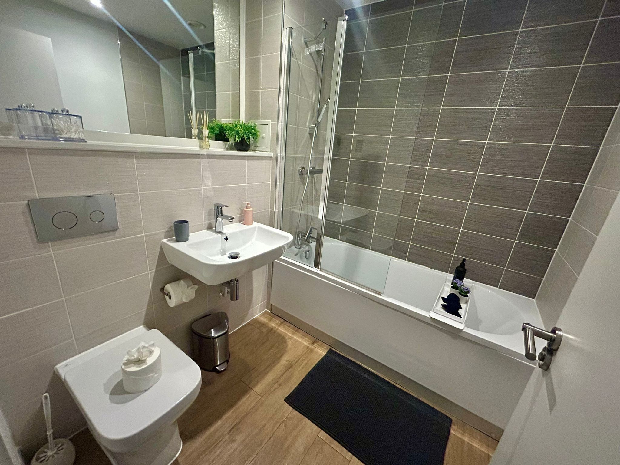 Un bagno moderno con WC, lavandino e doccia.