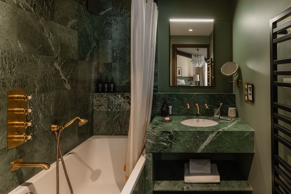 A bathroom with a bathtub, a sink, a mirror, and a shower.