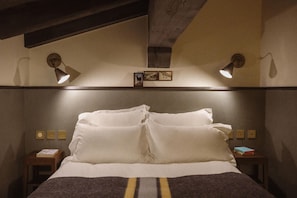 A hotel room with a bed, two bedside tables, wall-mounted lamps, and a small picture frame. - Le Fitz Roy (Les Belleville)