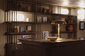 A bar area with a counter, shelves with various items, and a lamp. - Le Fitz Roy (Les Belleville)