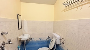 Une salle de bain avec des toilettes, un lavabo et une douche.