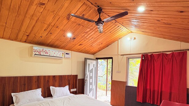 Une chambre avec un plafond en bois, un lit, une table et une chaise.