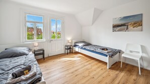 A bedroom with a bed, a chair, a nightstand, and a window. - Fully equipped apartments in Metzingen - ideal for fitters & companies (3 units) (Metzingen)