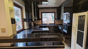 A modern kitchen with a central island, black countertops, and stainless steel appliances.