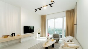 A modern living room with a flat-screen TV, a sofa, a coffee table, and a large window with curtains. - Dubai Frame & Skyline View 2BR – 42nd Floor, Pool & Gym (Dubai)