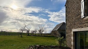 A stone house with a patio and outdoor seating. - Lovely Holiday Cottage in Corseul (Corseul)