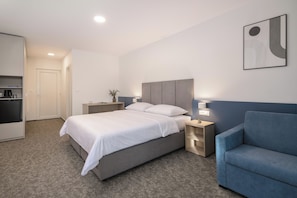 A modern hotel room with a bed, bedside tables, a sofa, and a wall-mounted artwork. - Alemaris Resort (Baška Voda)