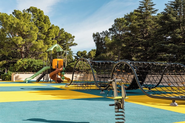 A playground with a climbing structure and slides. - Alemaris Resort (Baška Voda)