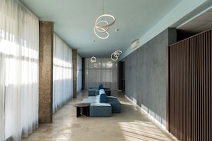 A modern interior with a long corridor, seating area, and a large window with sheer curtains. - Alemaris Resort (Baška Voda)