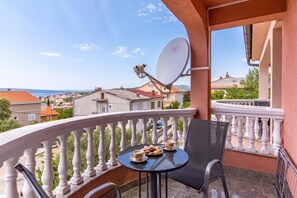 A balcony with a table, chair, and satellite dish. - Pool Apartments Novi Vinodolski (Novi Vinodolski)