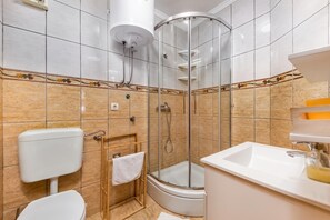 A bathroom with a glass-enclosed shower, a toilet, and a sink. - Pool Apartments Novi Vinodolski (Novi Vinodolski)