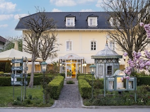 A building with a cafe and restaurant, a cobblestone pathway, and a small gazebo. - Geraumiges Studio in Bad Birnbach (Bad Birnbach)