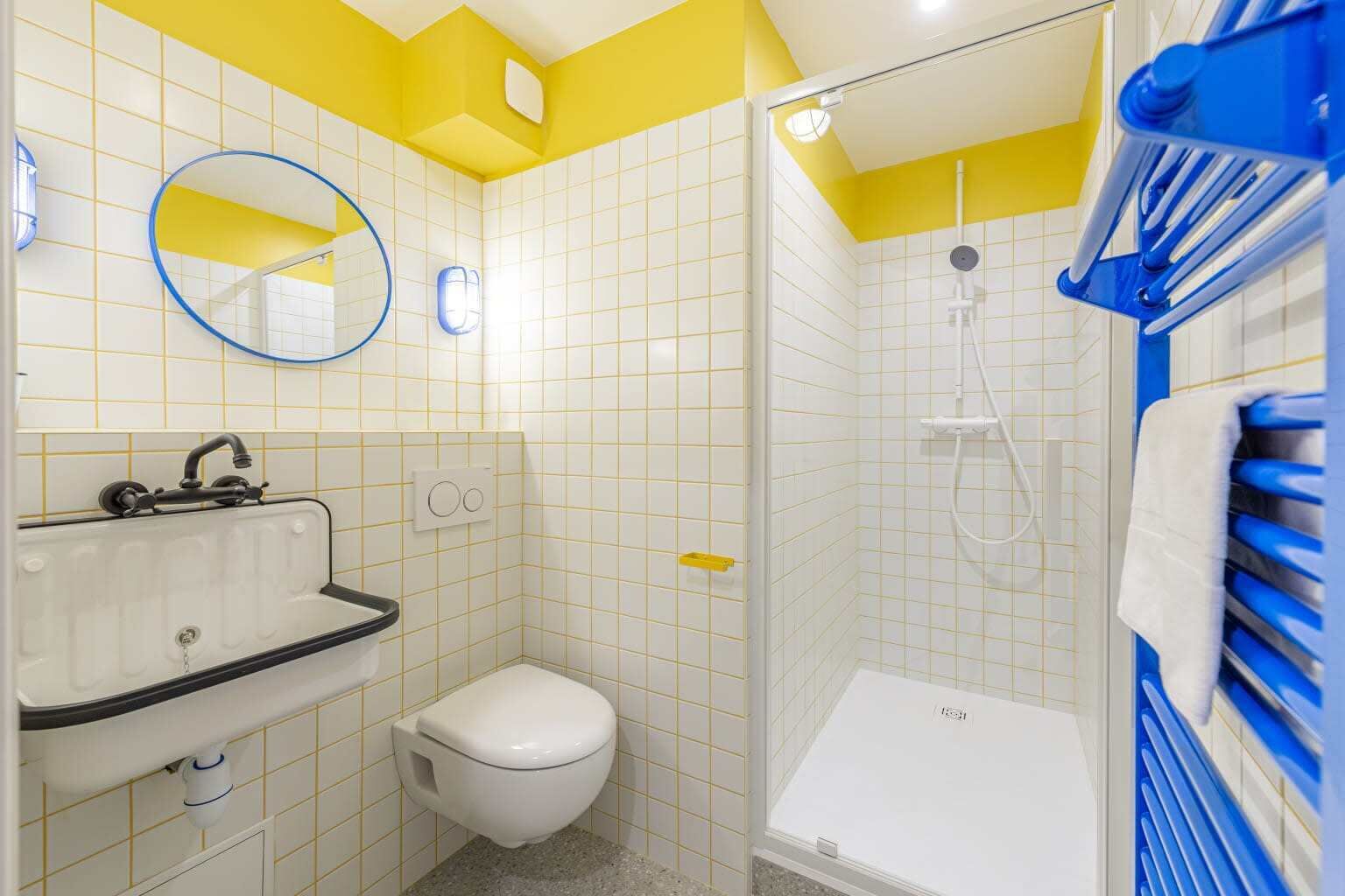 A bathroom with a white sink, toilet, and shower.