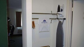 A hotel room with a bed, a small table, a chair, a towel rack, and a sign indicating the room is part of the Americas Best Value Inn. - Jacksonville Inn (Jacksonville)