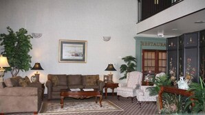 A spacious living room with a sofa, armchairs, a coffee table, and a dining area with a sign reading "RESTAURANT". - Jacksonville Inn (Jacksonville)