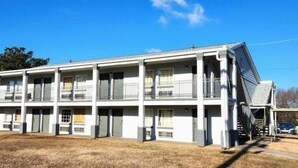 A multi-story motel with a central corridor and individual rooms on each floor. - Jacksonville Inn (Jacksonville)